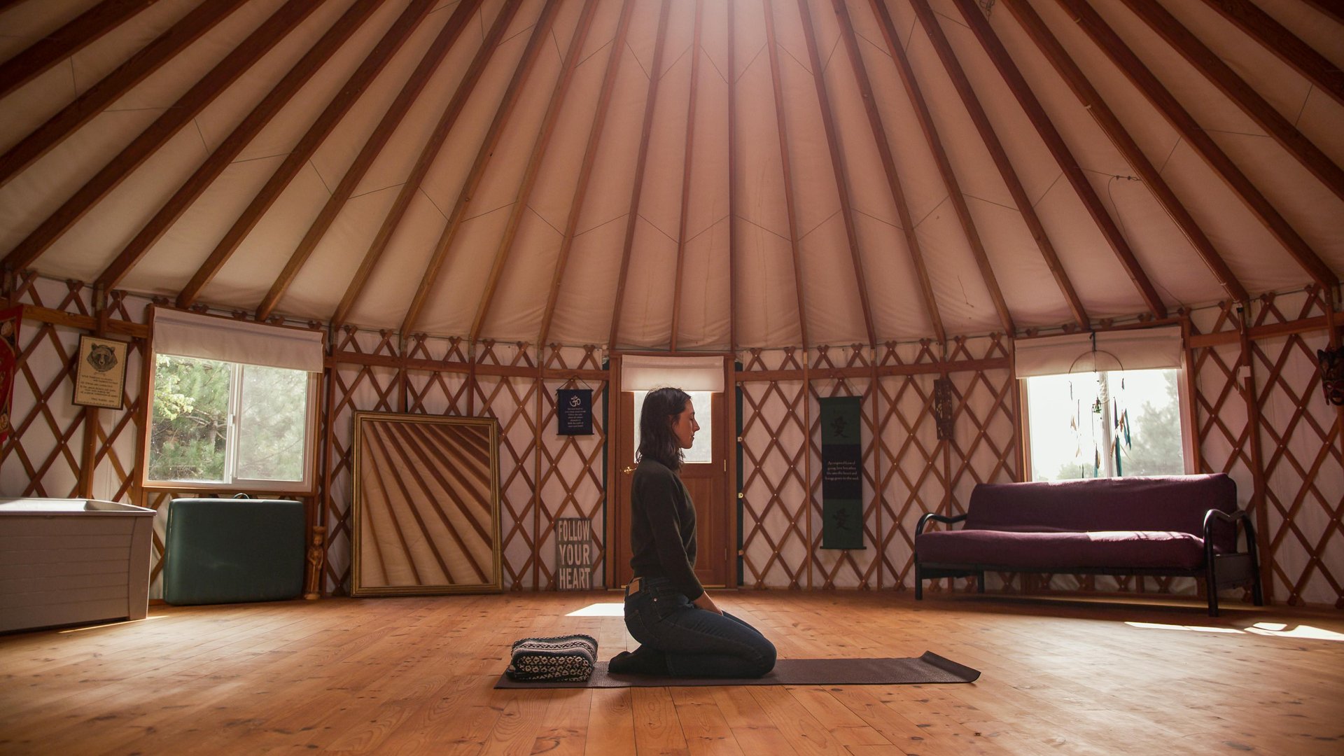 Woman doing yoga in a yurt