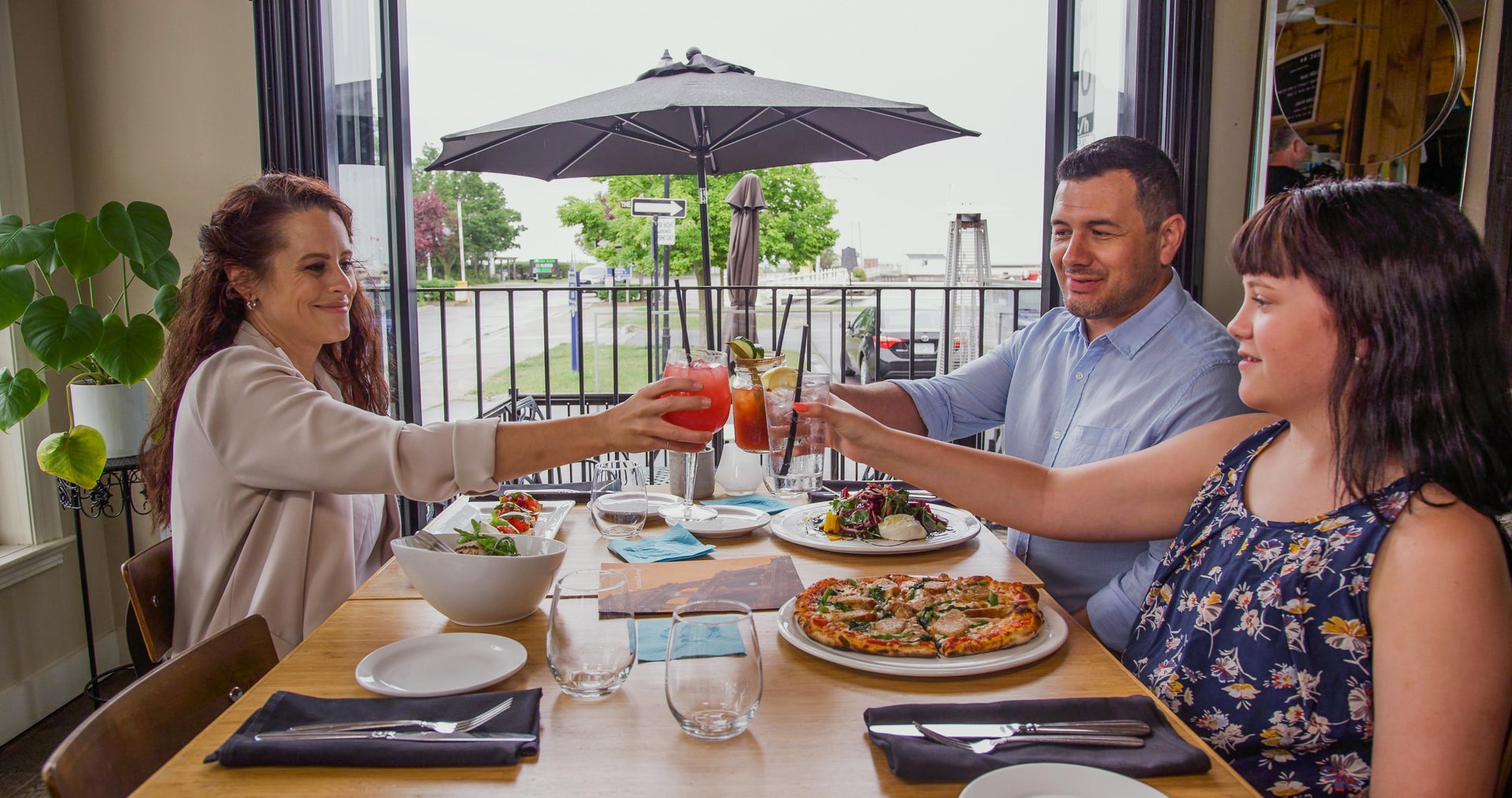 Family toasting at a restaurant looking over a marina
