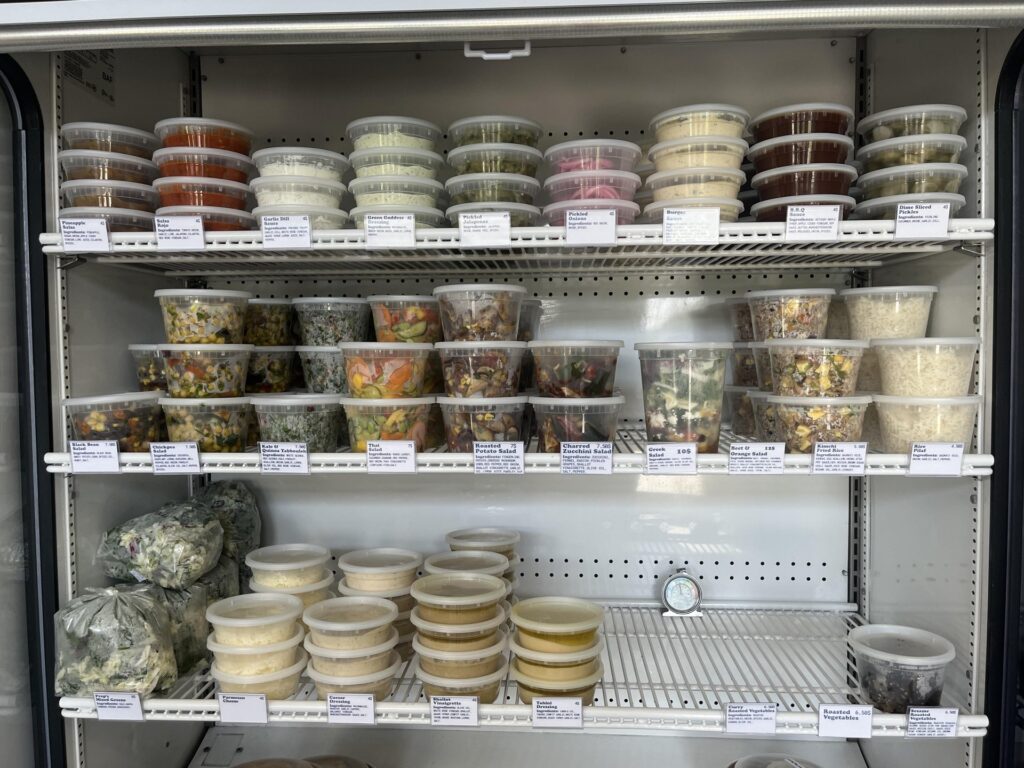 Fridge filled with premade meals and sauces