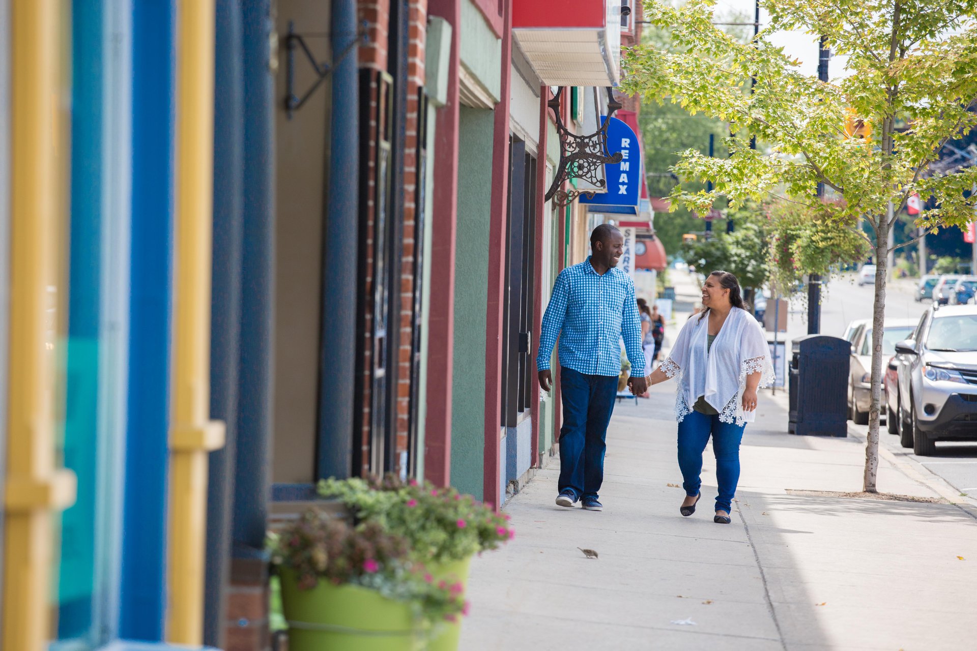 Couple holding hands walking down a small town street