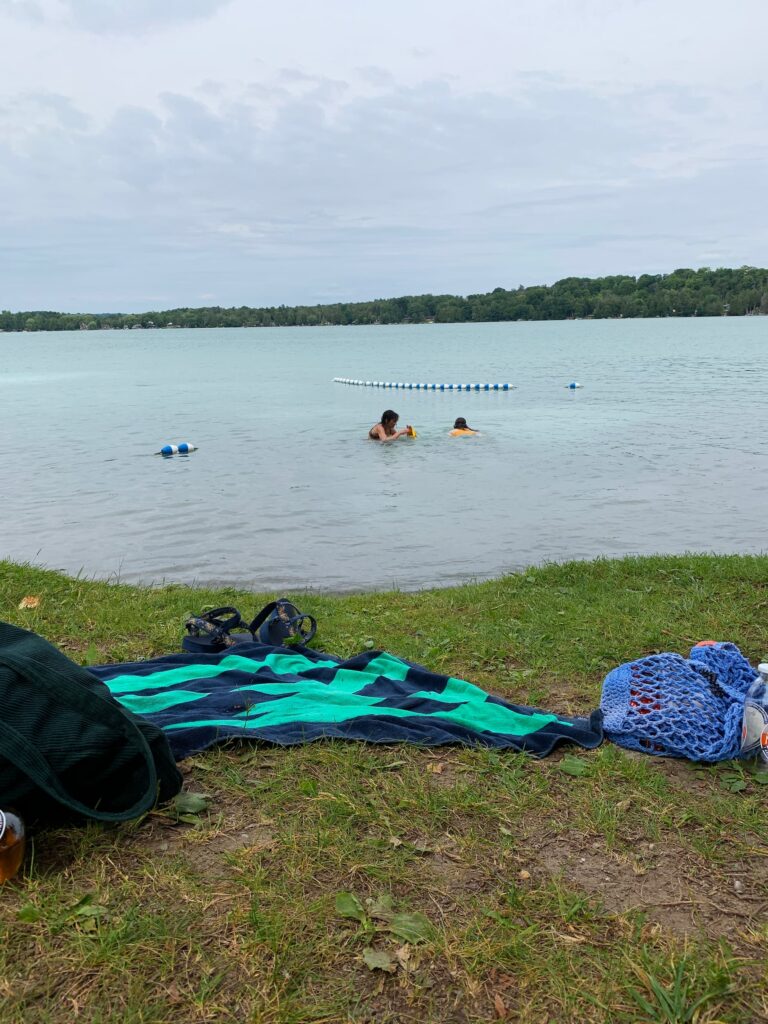 Two girls swimming at Little Lake with towels in the foreground