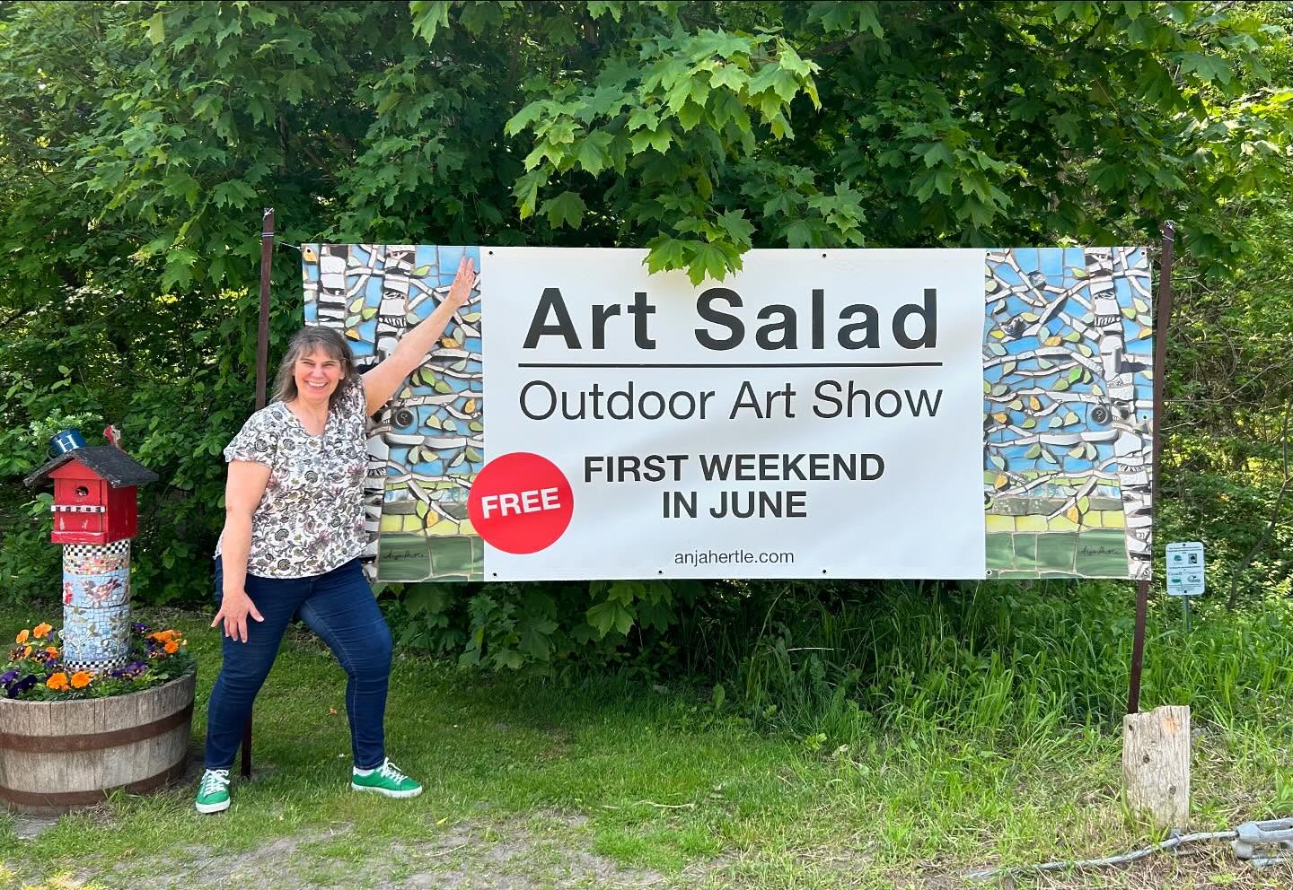 Woman pointing to Art Salad sign