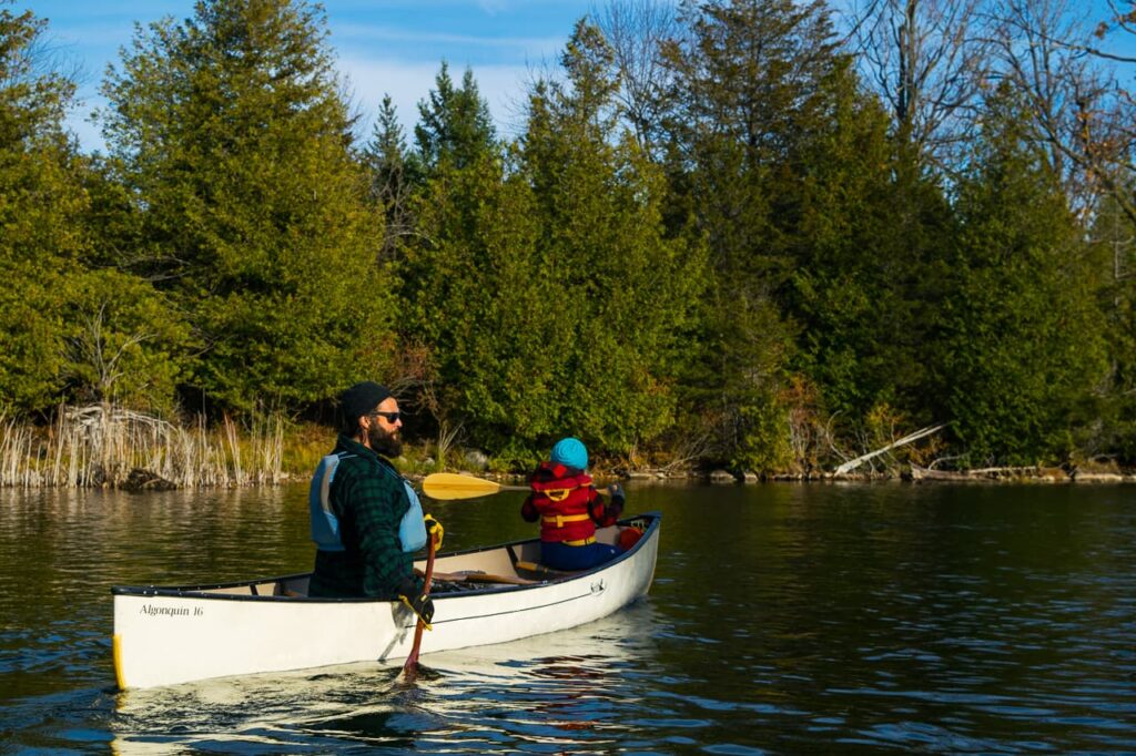 Father and child in white canoe in fall