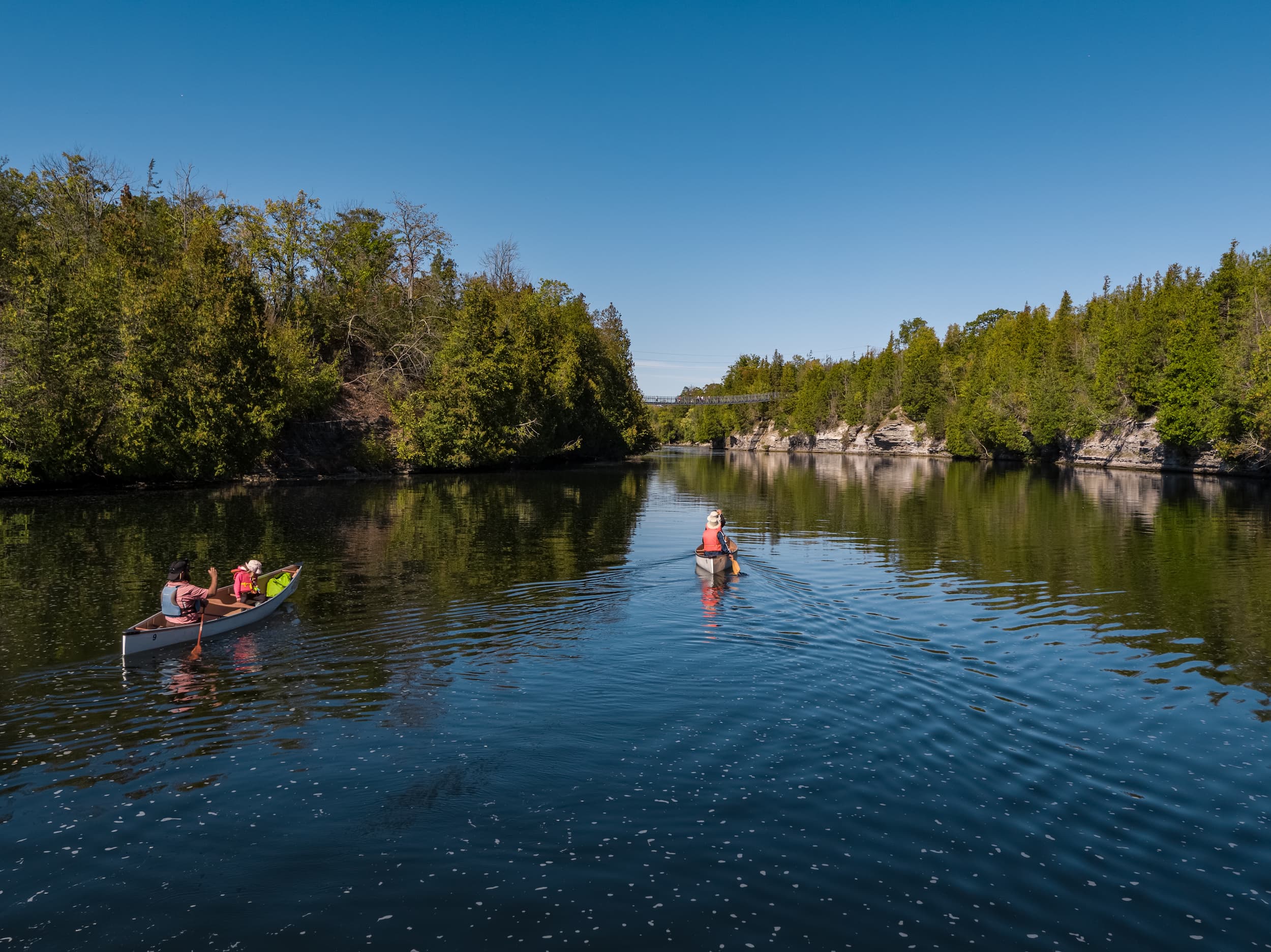 Two canoes paddling the Trent River in fall.