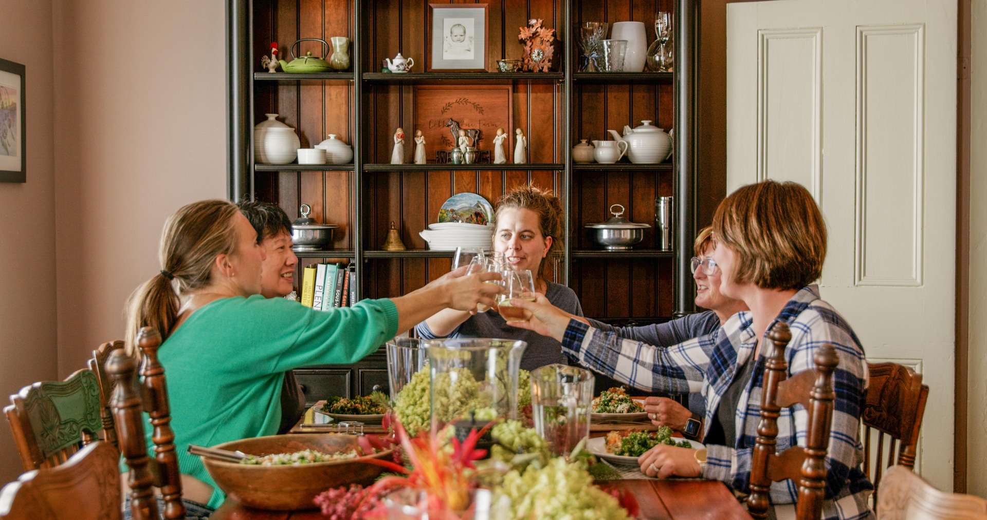 Group of women toasting at a large dining room table