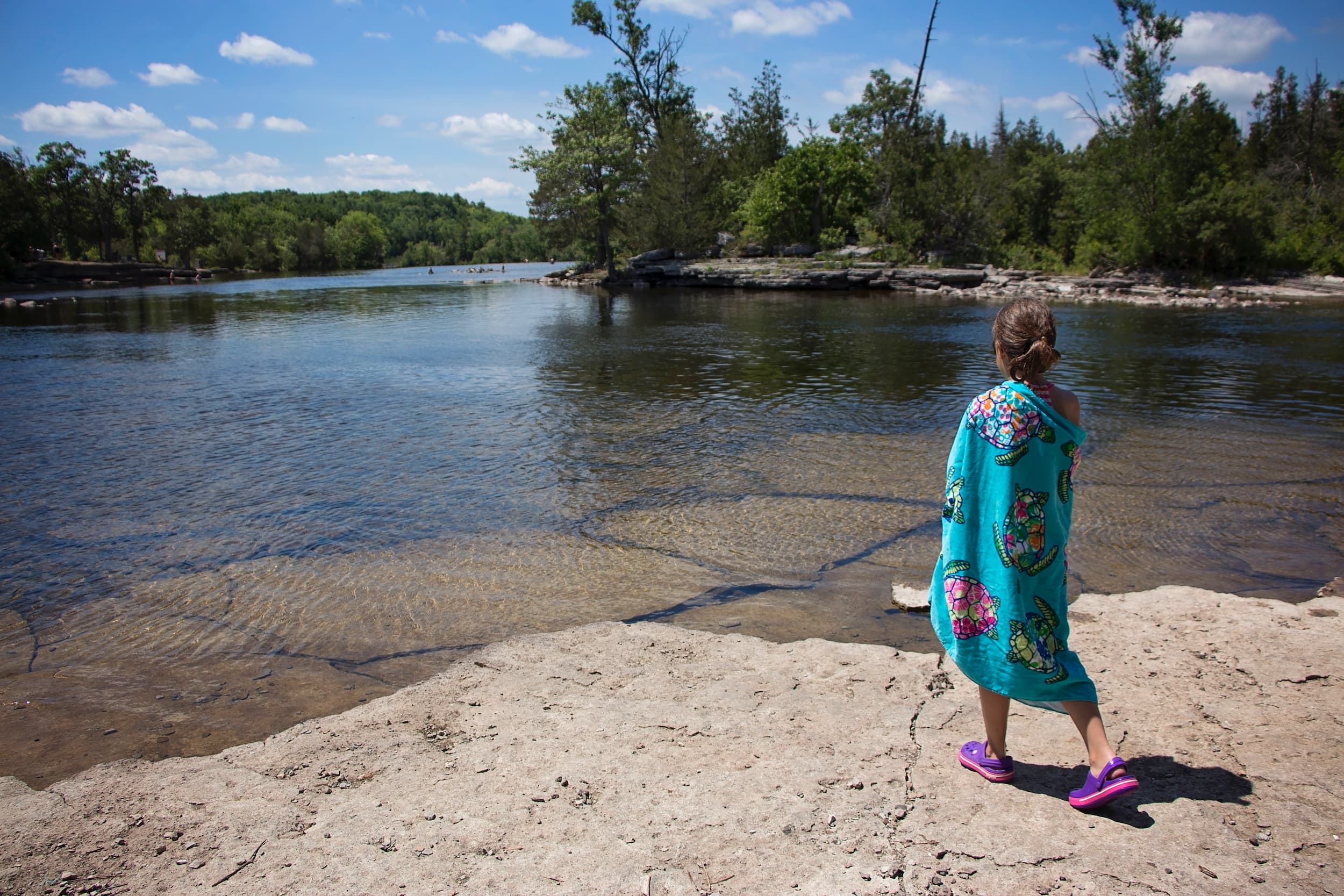 Girl wrapped in towel at the edge of the water at Crowe Bridge Park.