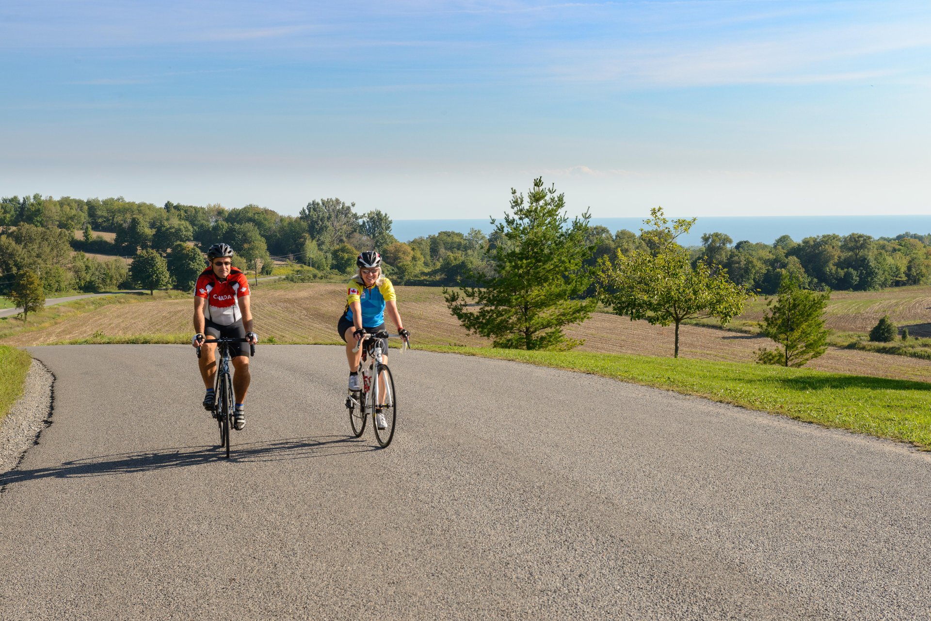 Two people riding bikes on a country road