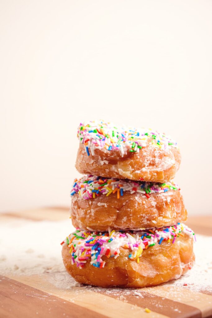 Stack of sprinkled donuts on a cutting board