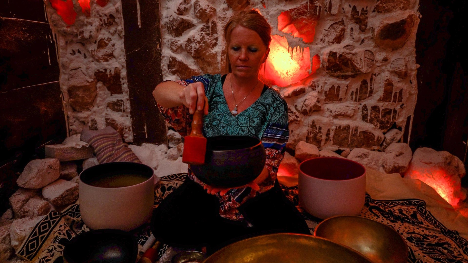 Woman performing sound therapy in a salt cave