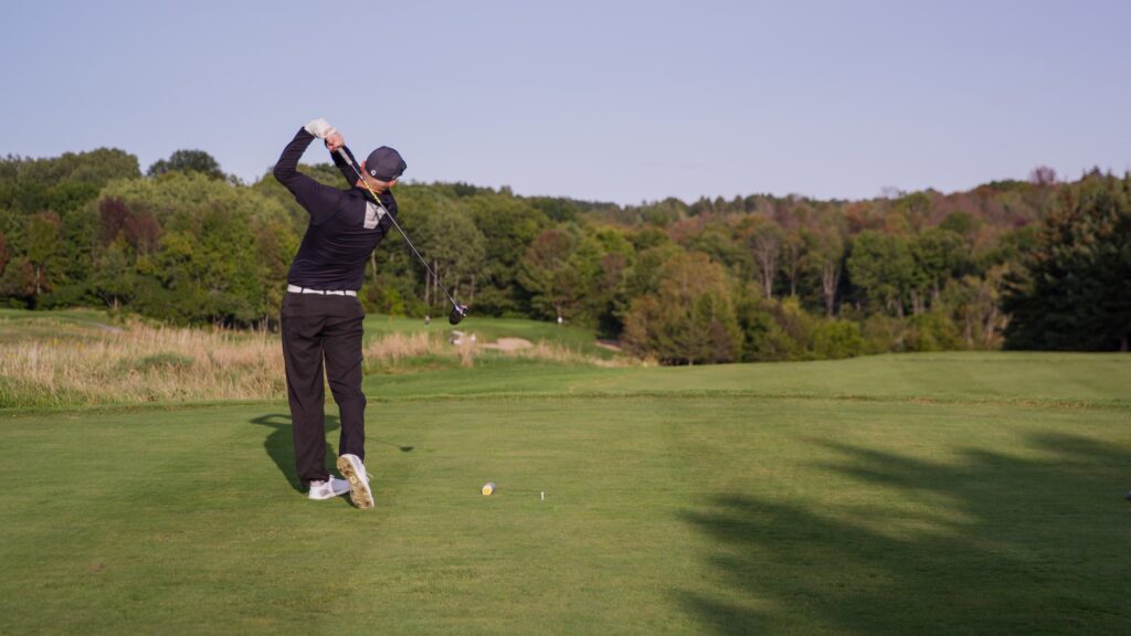 Man teeing off on a golf course.