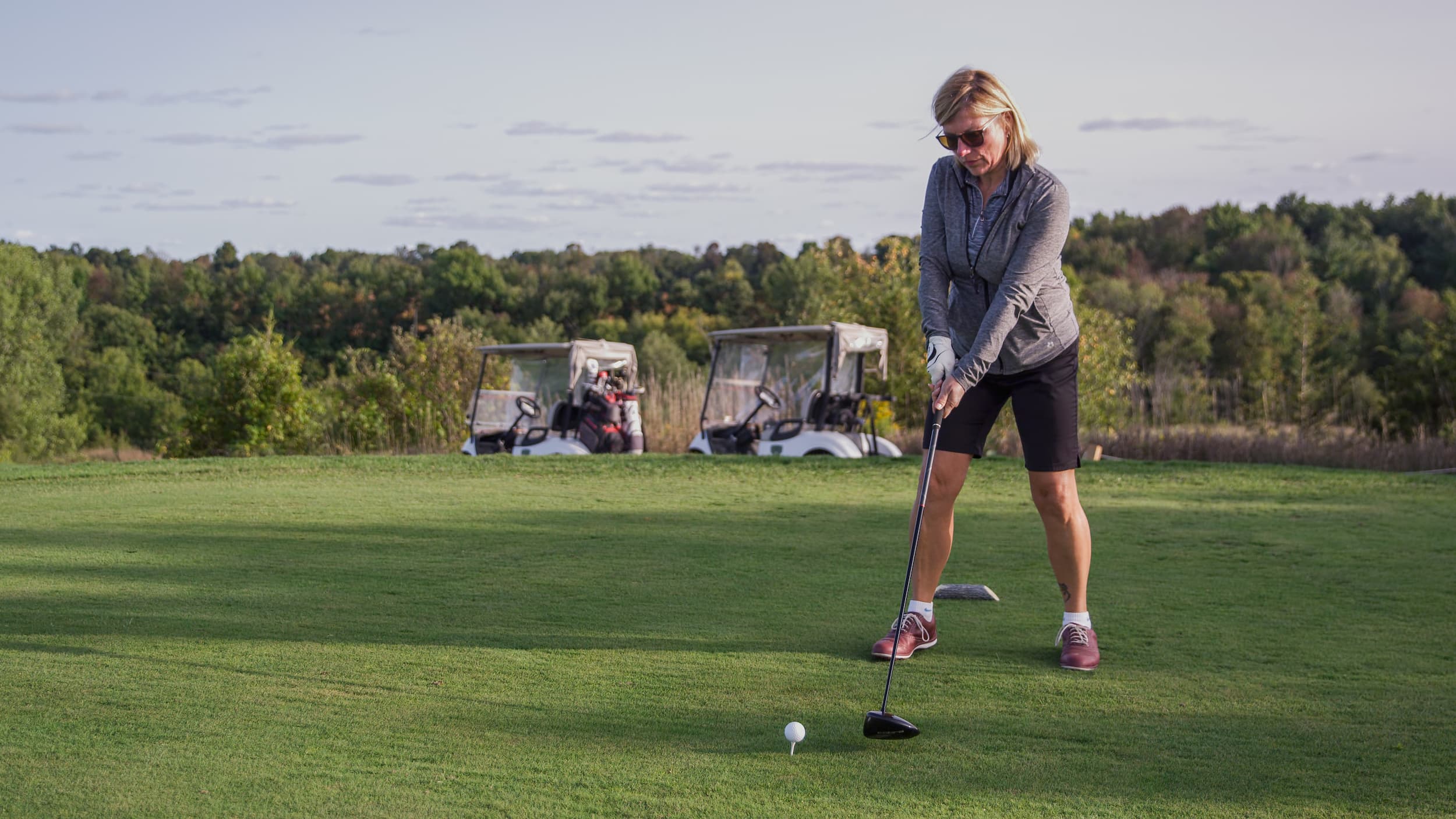 woman preparing to swing on a golf course.