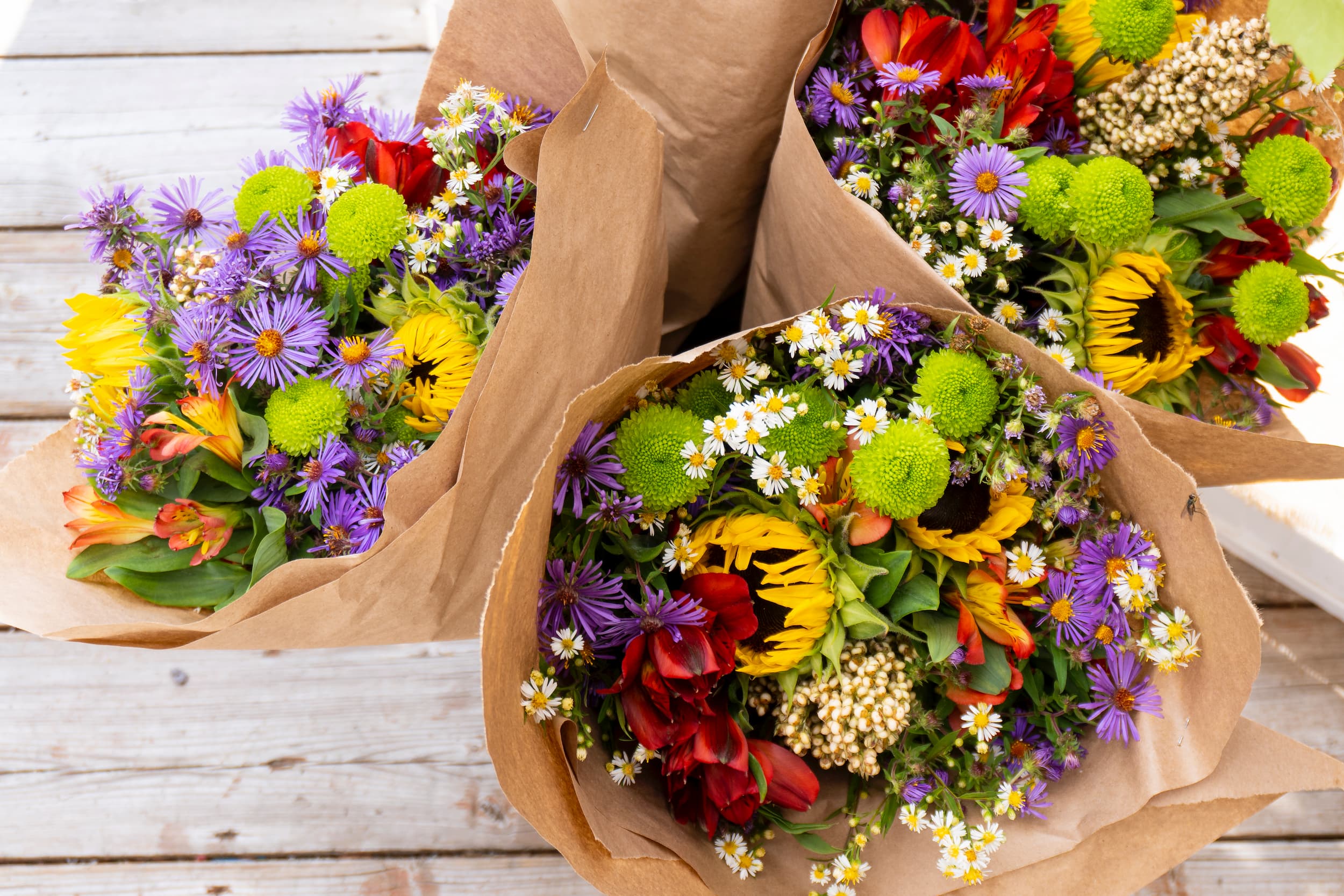 Top down view of bouquets of flowers wrapped in brown paper