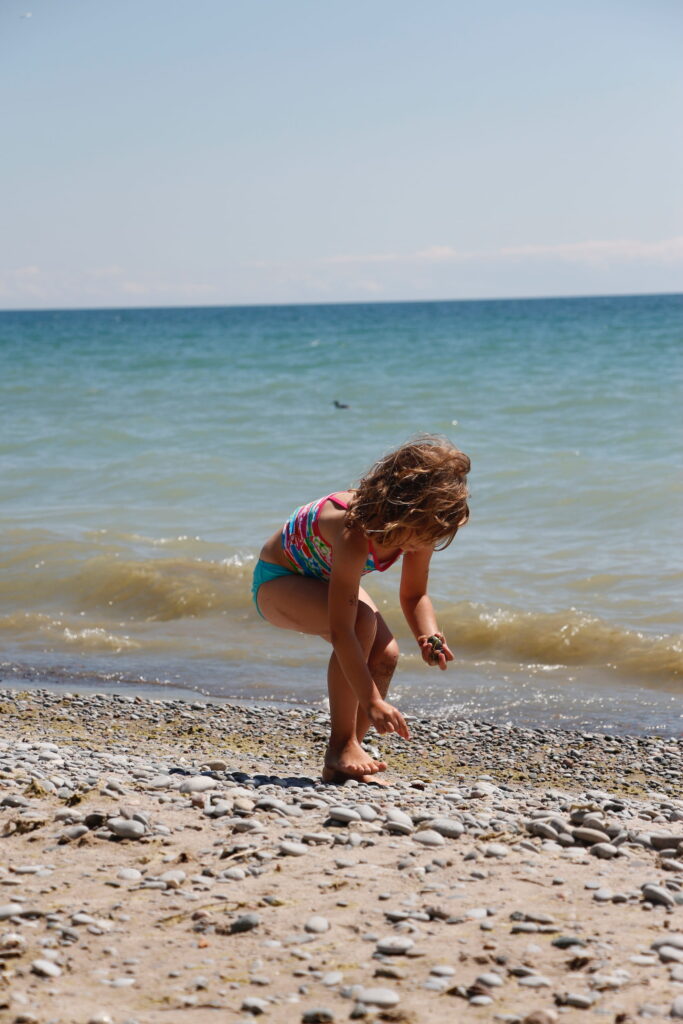 Young girl picking rocks at Wicklow Beach