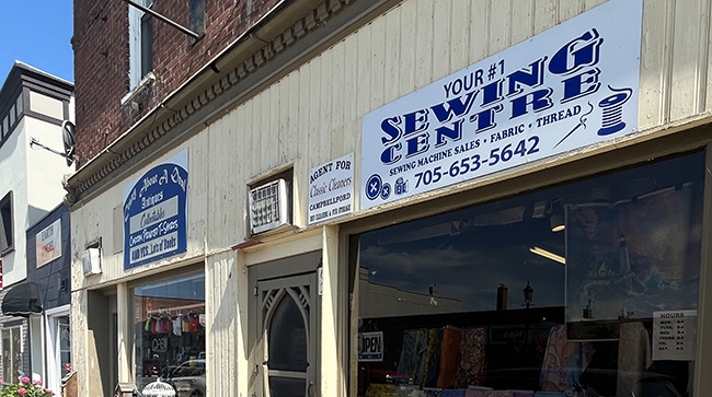 Beige building with a white sign with blue writing