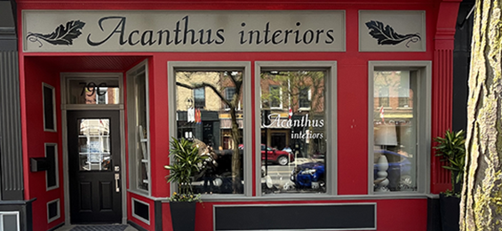 Front of a red, tan and black building with 3 large windows and a door