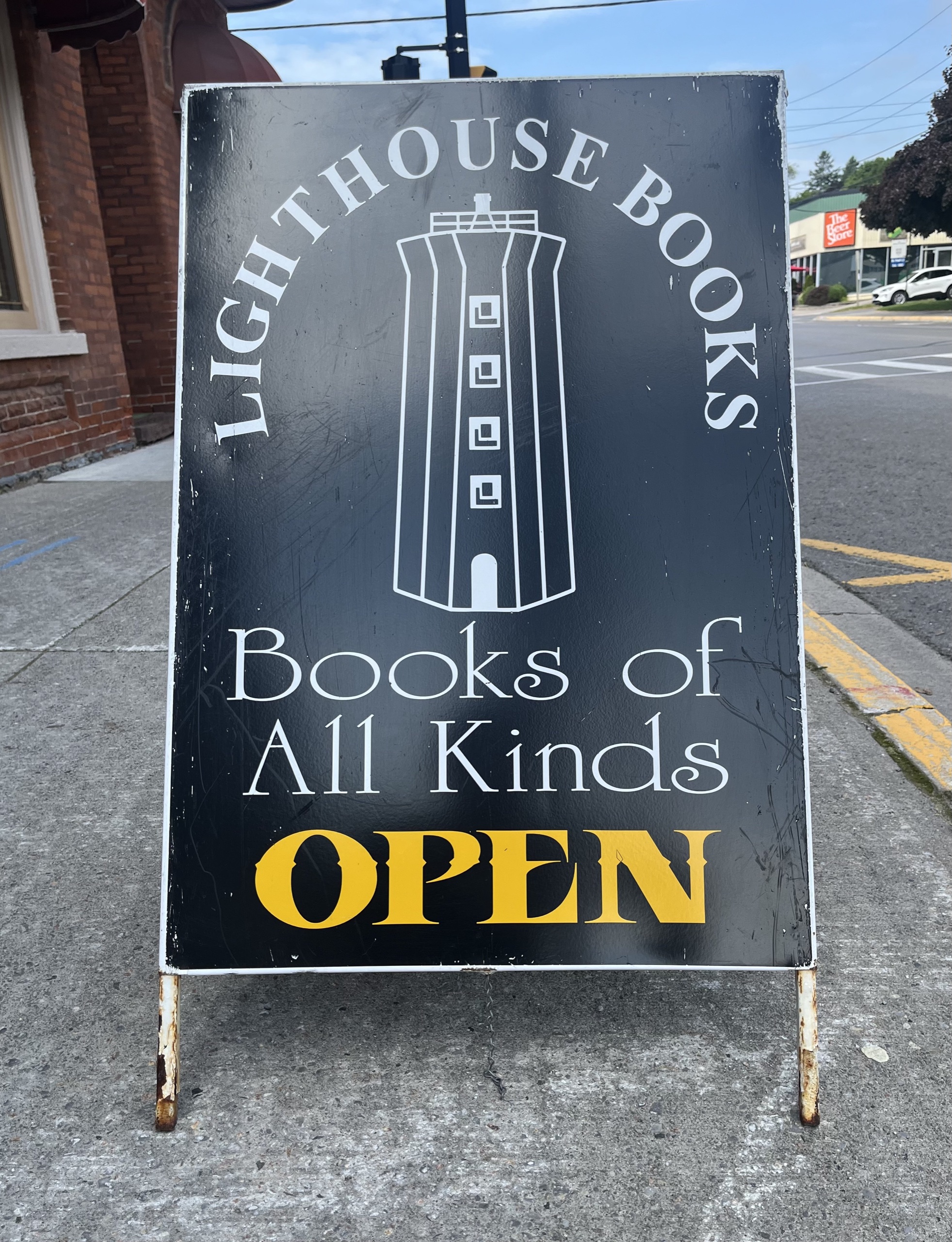 Photo of Lighthouse Books sign. Sign reads "Lighthouse Books. Books of all kinds open."
