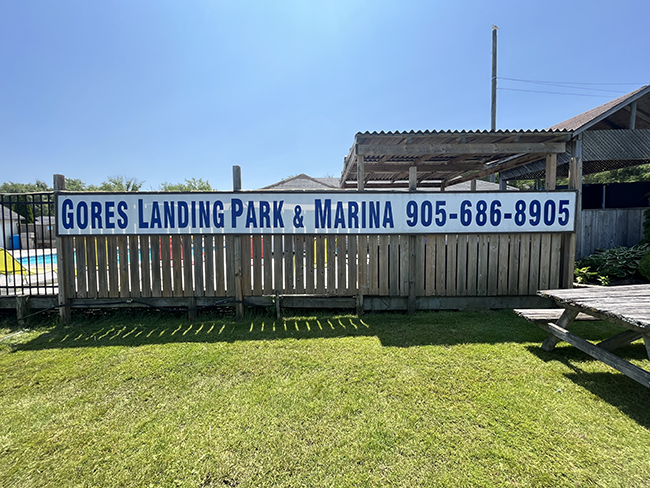Fence around a pool with white and blue sign.