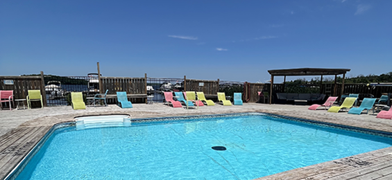 Inground pool with neon lounge chairs on the pool deck.