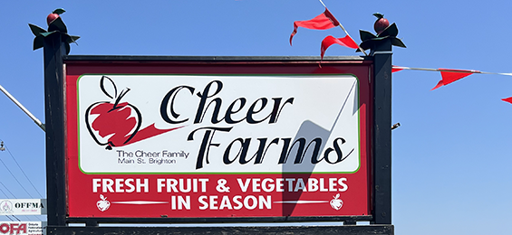 Red and white Cheer Farms sign with an apple