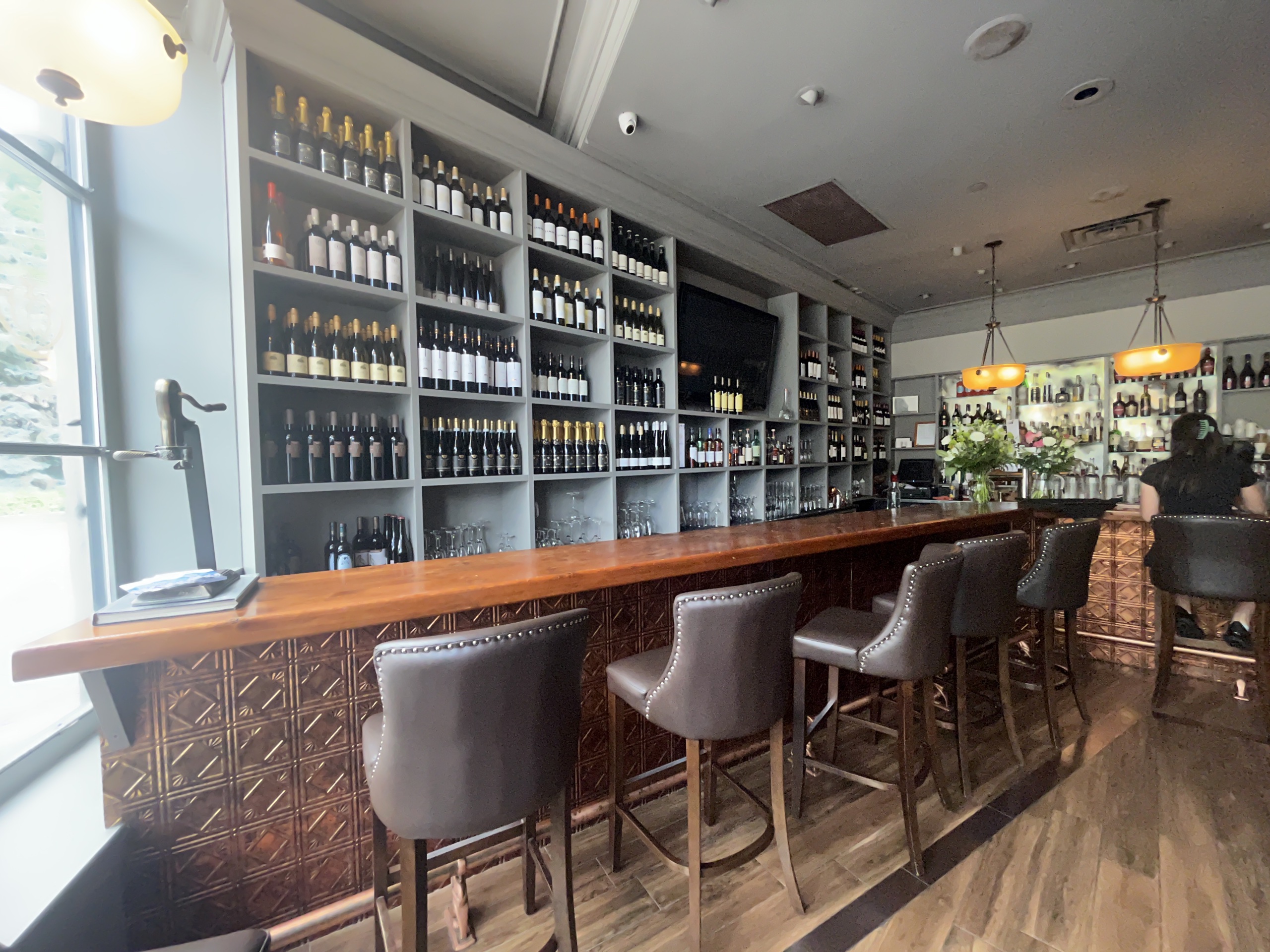 Photo of the bar, inside the restaurant. Copper bar with leather seating.
