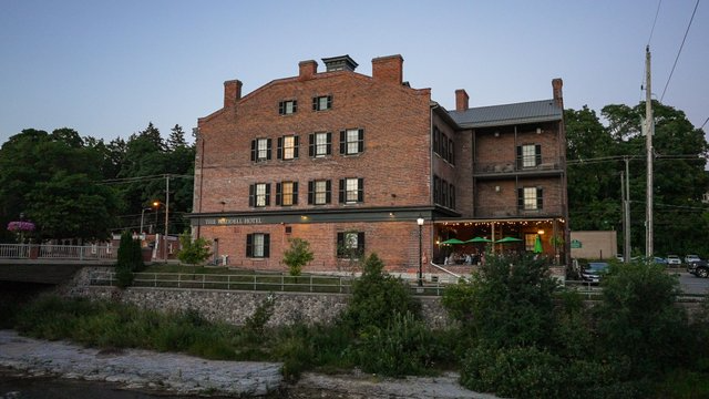 Exterior photo of the restaurant. Red brick building overlooking the river.