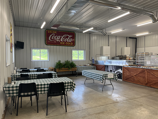 Black and white plaid tables and chairs across from ice cream and baked good items.