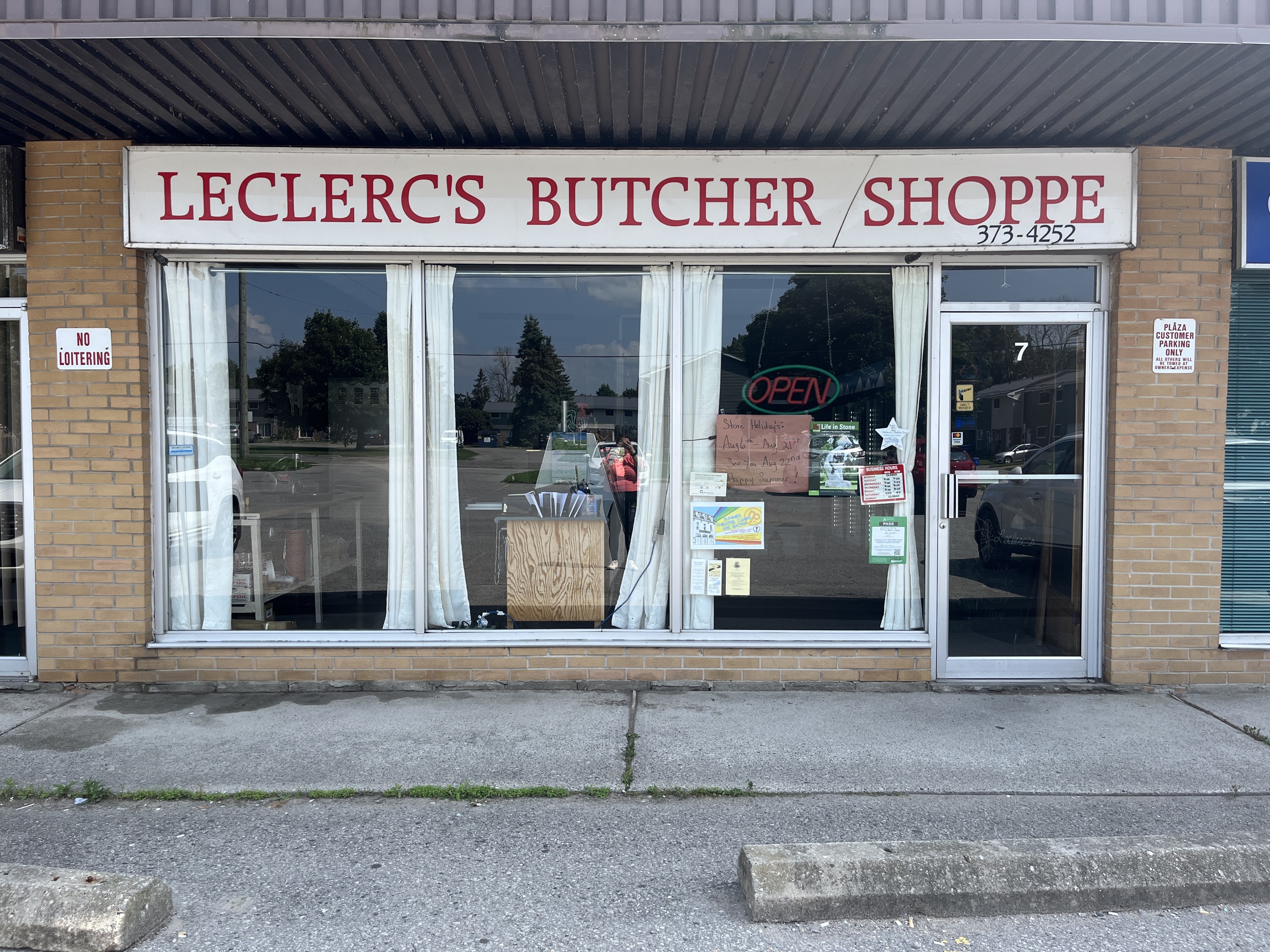 Photo of Leclerc's Butcher Shoppe storefront. Photo shows a sign above the window and door entrance reading "Leclerc's Butcher Shoppe. 373-4252."