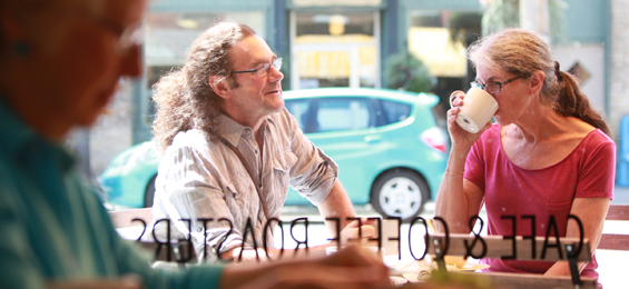 Man and woman sitting at a table drinking a coffee.