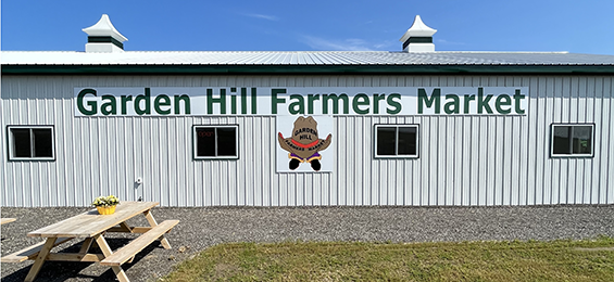 Large white building with green writing and a cowboy hat logo.