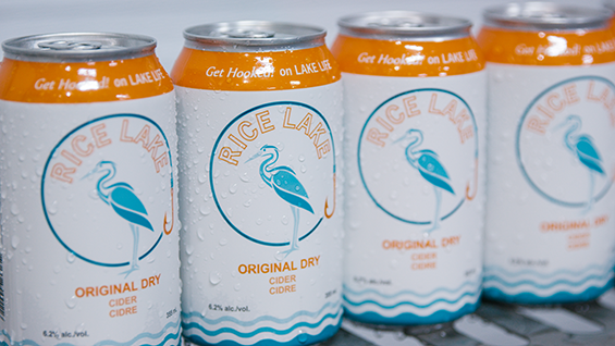 4 white cans with orange and blue finishings lined in a row.