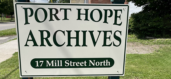 White sign with dark green writing.