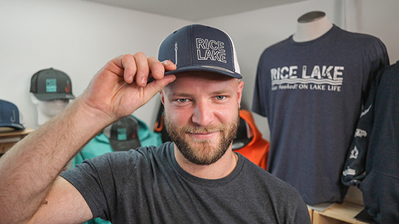 Man wearing a grey hat in front of other apparel.