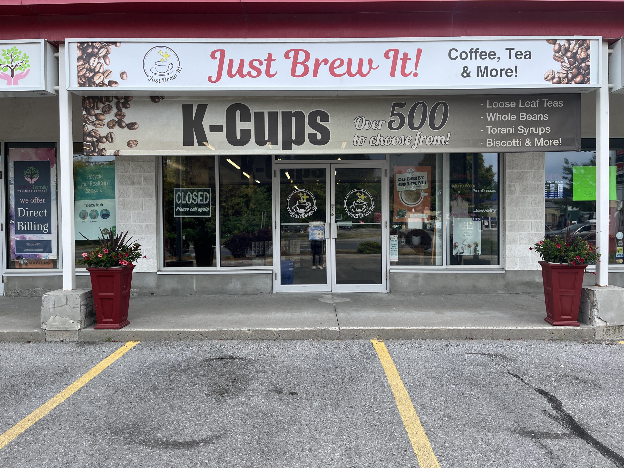 Photo of Just Brew It! storefront. Photo shows a sign above the entrance door, reading "Just Brew It! Coffee, Tea & More!"