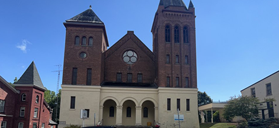 Beige and brick building with lots of windows.