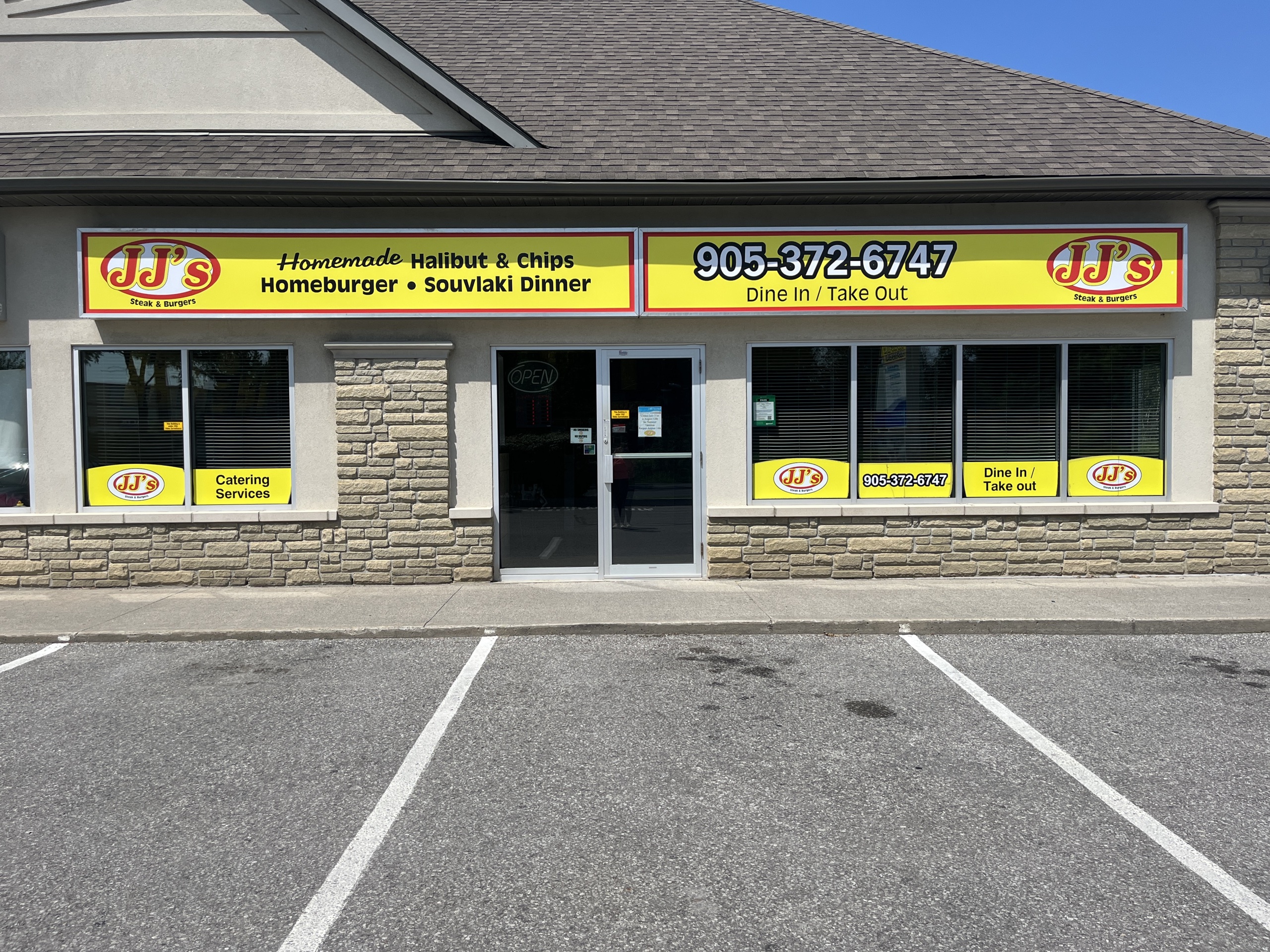 Photo of JJ's Steak & Burger storefront. Sign above the door reads "JJ's Steak & Burger. Homemade Halibut & Chips, Homeburger, Souvlaki Dinner. 905-372-6747. Dine in/Take out."
