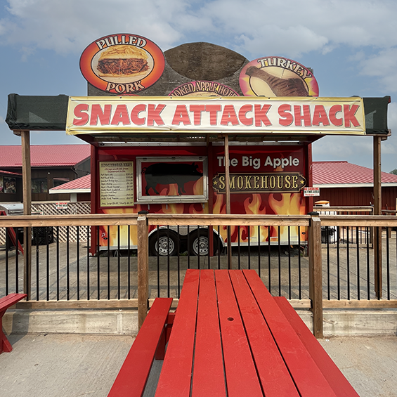 Red food truck with flames painted on it and a deck built in front.