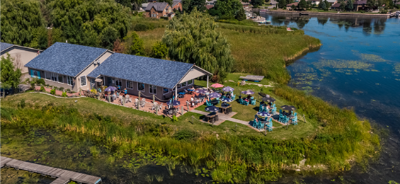 Large building with wrap around patio facing the waterfront.