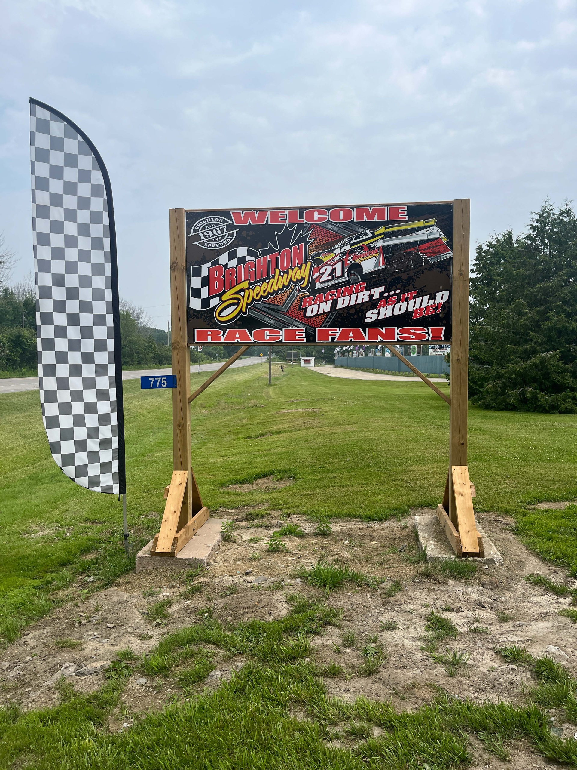 Photo of Brighton Speedway sign. Sign reads "Brighton Speedway. Welcome race fans! Racing on dirt as it should be!"