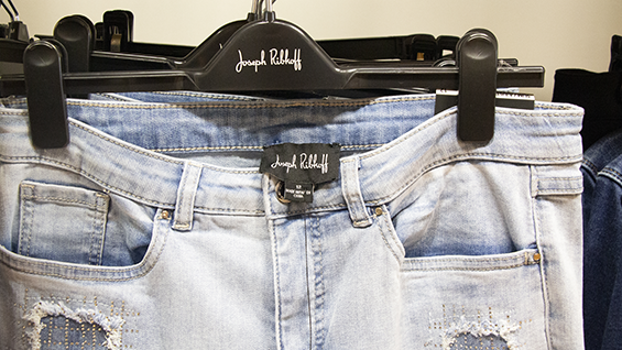 Pair of light wash jeans hanging on a black hanger.