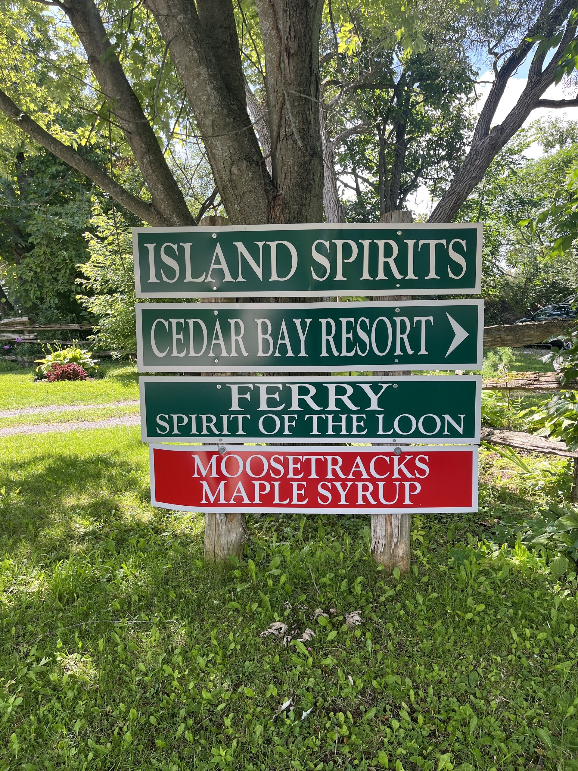 Photo of Island Spirits sign. Sign reads "Island Spirits. Cedar Bay Resort. Ferry Spirit of the Loon. Moosetracks Maple Syrup."