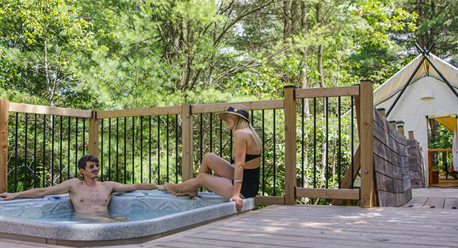 man and woman in a hot tub in a large deck.