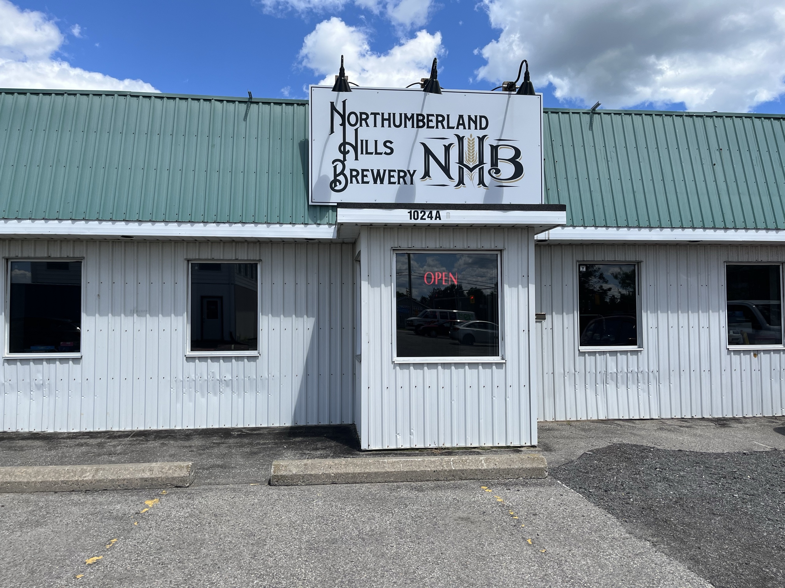 Photo of the outside of Northumberland Hills Brewery. The sign above the entrance reads "Northumberland Hills Brewery" with the business' logo beside the text.