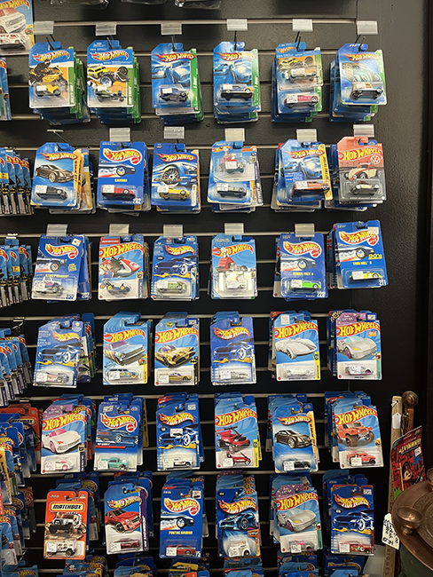 Wall of small blue boxes with scale model cars.