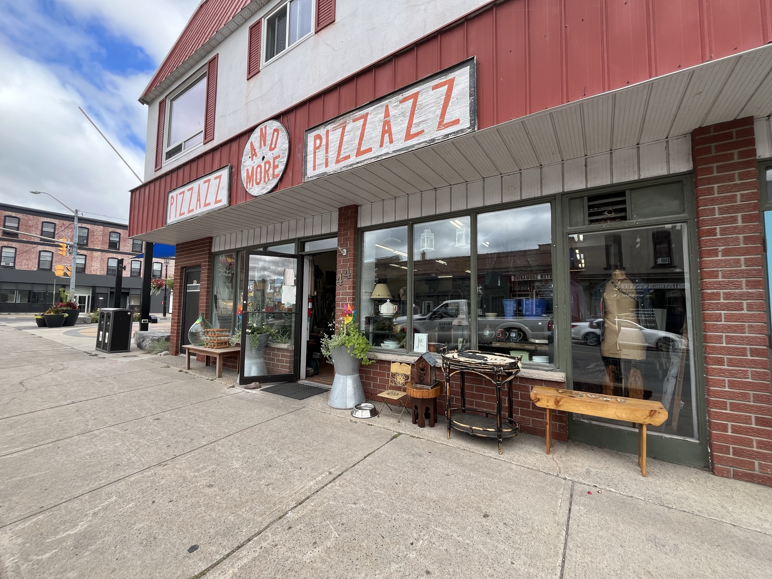 Photo from outside of Pizzazz Vintage. Sign above entrance reads "Pizza Anomore Pizzazz."