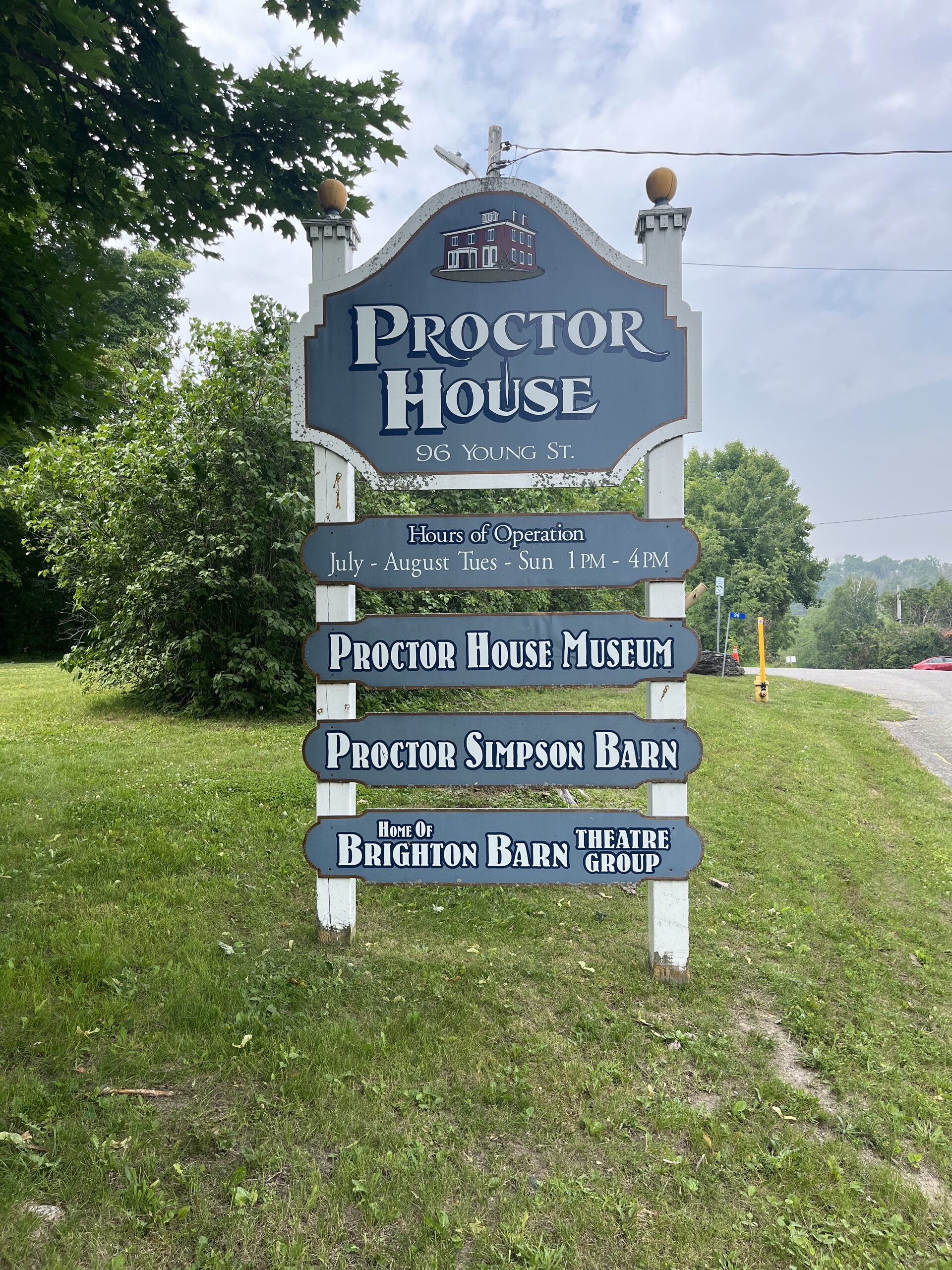 Photo of Proctor House sign. Sign reads "Proctor House 96 Young St. Hours of Operation July to August. Tues to Sun 1pm to 4pm."
