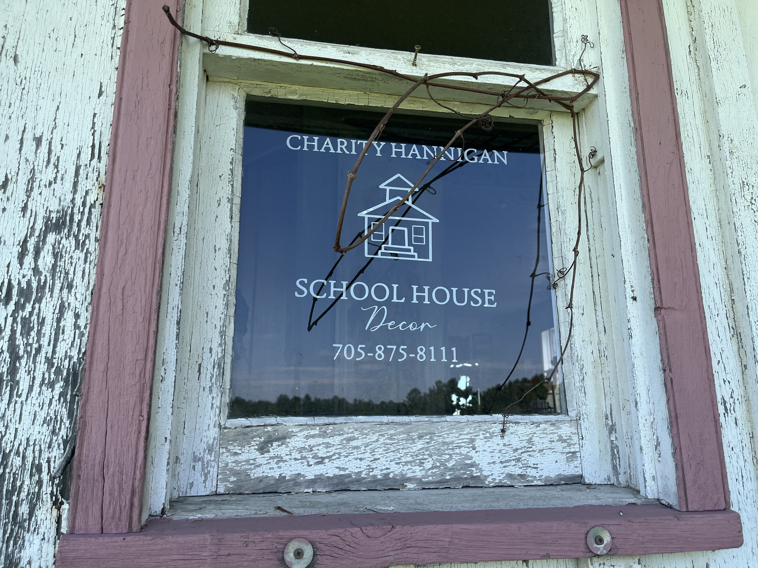 Photo of School House Decor window. Writing on window reads "Charity Hannigan School House Decor. 705-875-8111."
