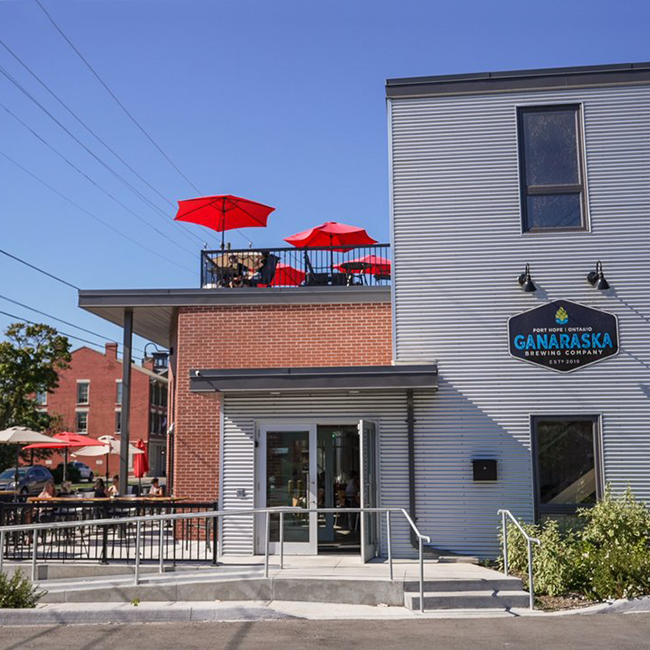 Grey and brick building with a front patio and a rooftop patio