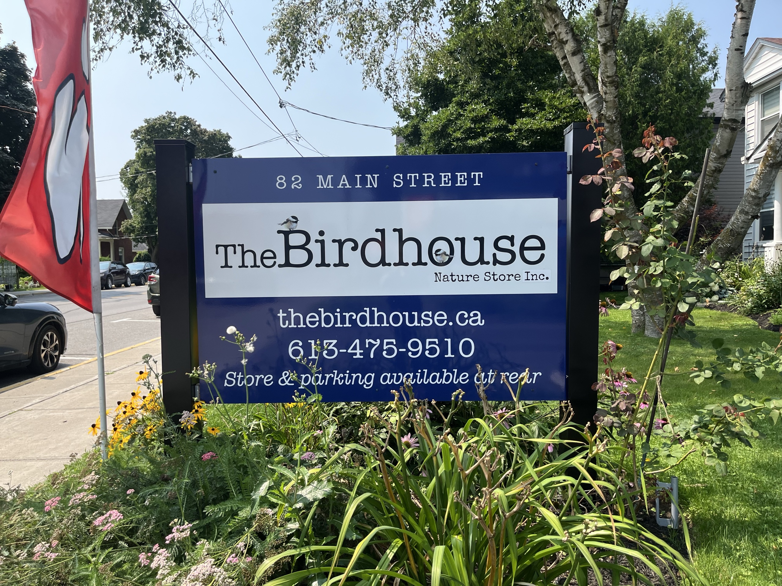 Photo of The Birdhouse sign. Sign reads "82 Main Street. The Birdhouse Nature Store. thebirdhouse.ca. 613-475-9510."
