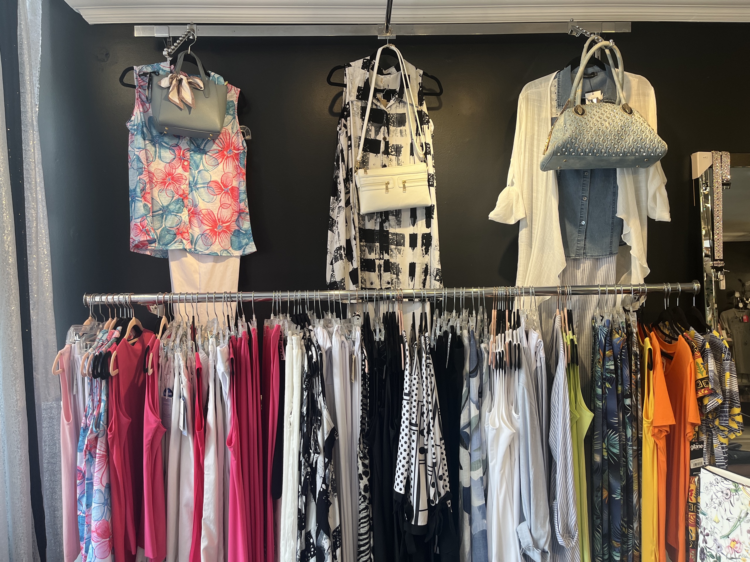 Many shirts hanging on the wall.
