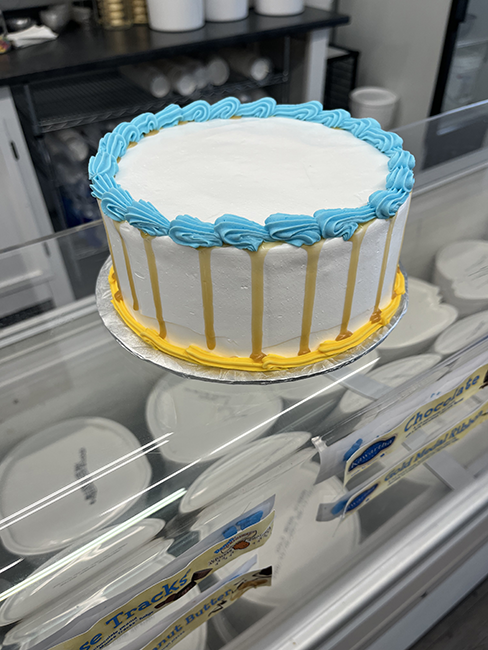 White round cake with blue and yellow frosting borders